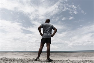 Black runner contemplating landscape