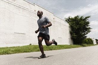 Black man running on city street