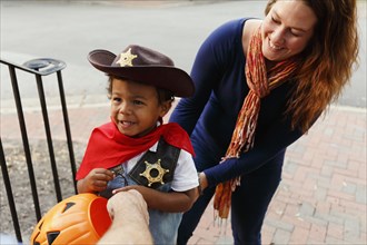 Mother with son trick dressed as cowboy for Halloween