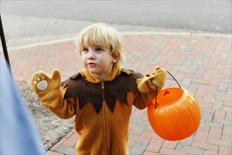 Caucasian boy in lion costume trick or treating on Halloween