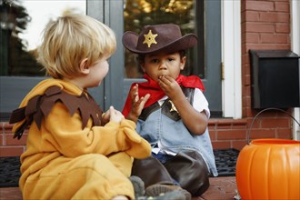 Boys in costumes eating Halloween candy