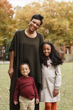 African American mother and children smiling in park