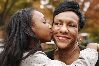 Close up of African American girl kissing mother