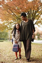 African American mother walking with daughter in park