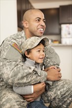Mixed race soldier father hugging son