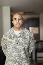 Mixed race soldier standing in living room