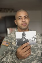 Mixed race soldier holding photograph of father