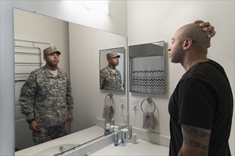 Mixed race man seeing soldier in mirror