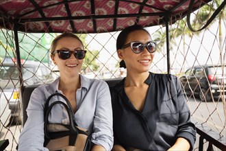 Businesswomen riding in tuk tuk taxi