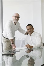 Hispanic businessmen smiling in office meeting
