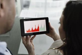 Business people viewing graph on digital tablet