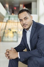 Hispanic businessman sitting in hotel lobby