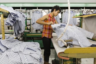 Asian worker ironing shirt in garment factory