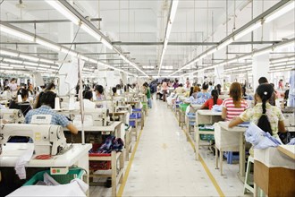 Asian worker sewing clothing in garment factory