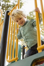 Caucasian boy on play structure in playground