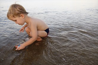 Caucasian boy playing in water on beach