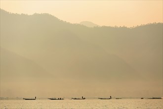 Silhouette of canoes floating on rural lake