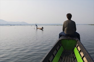 Caucasian man sitting on canoe on rural lake