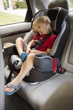 Caucasian boy napping in car seat