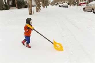 Caucasian boy shoveling snow