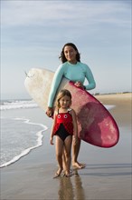 Mother and daughter smiling on beach