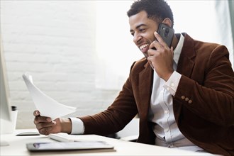 African American businessman talking on cell phone in office