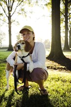 Caucasian woman hugging dog in park