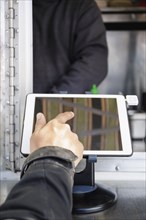 Man paying at food cart using digital tablet