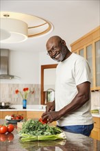Black man chopping vegetables in kitchen