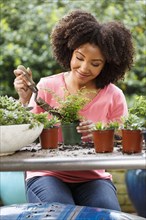 Black woman gardening at table outdoors