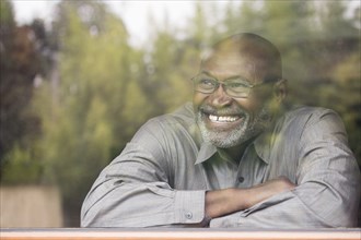 Smiling Black man behind window