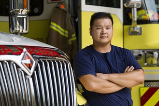 Serious Chinese fireman posing with fire truck