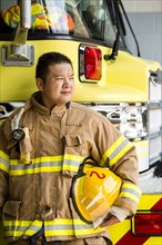 Chinese fireman standing near fire trucks