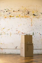 Paint splattered on wall near cardboard boxes