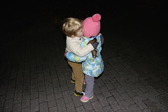 Boy ad girl hugging outdoors at night