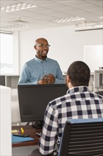 Men talking in office near computer