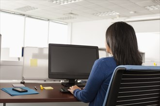 Pacific Islander woman using computer in office