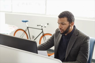 Mixed Race man using computer in office