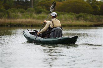 Caucasian man paddling kayak