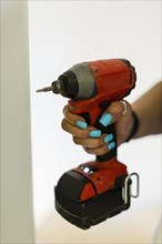 Hand of black woman holding drill