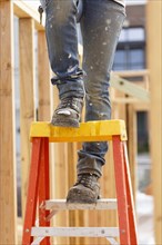 Legs of Caucasian woman on ladder at construction site