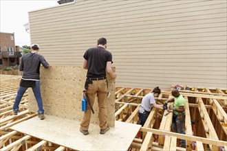 Volunteers holding plywood at construction site
