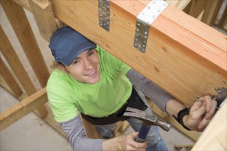 Caucasian man hammering nail at construction site
