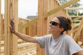 Smiling Caucasian woman leaning on frame a construction site