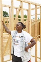 Mixed race man leaning on lumber at construction site