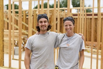 Caucasian man and woman posing at construction site