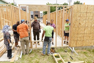 Volunteers holding wall at construction site