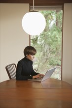 Caucasian woman using laptop on table