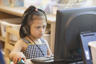 Mixed race Down syndrome student using computer