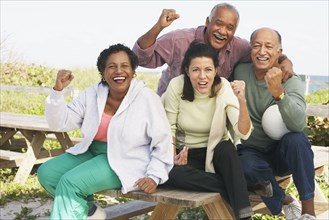 Two senior couples cheering outdoors